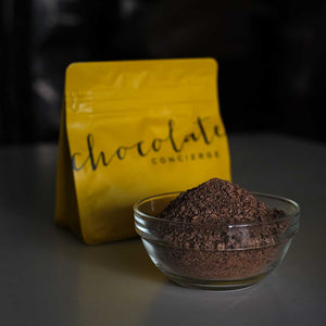 Chocolate Concierge artisan flakes from Malaysian single-origin cacao, beside packaging for preparing real bean-to-bar hot chocolate beverages.